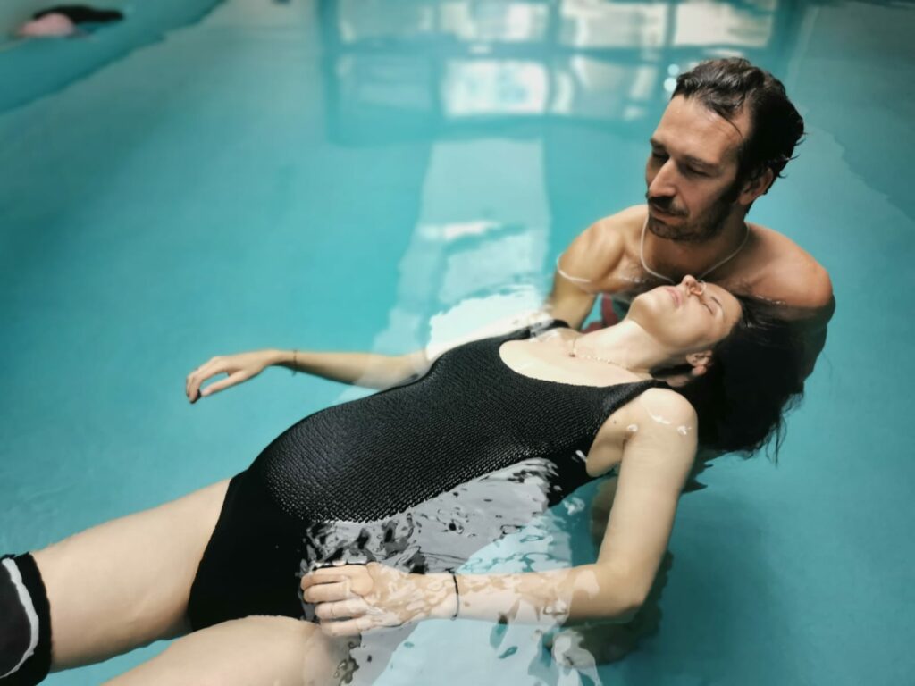 Relaxation aquatique : Valerio Dussi soutient une patiente enceinte allongée sur l'eau